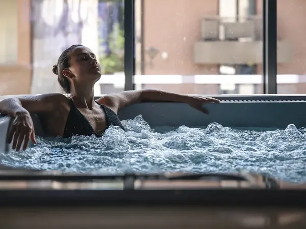 Femme qui se détend dans l’eau bouillonnante d’un spa